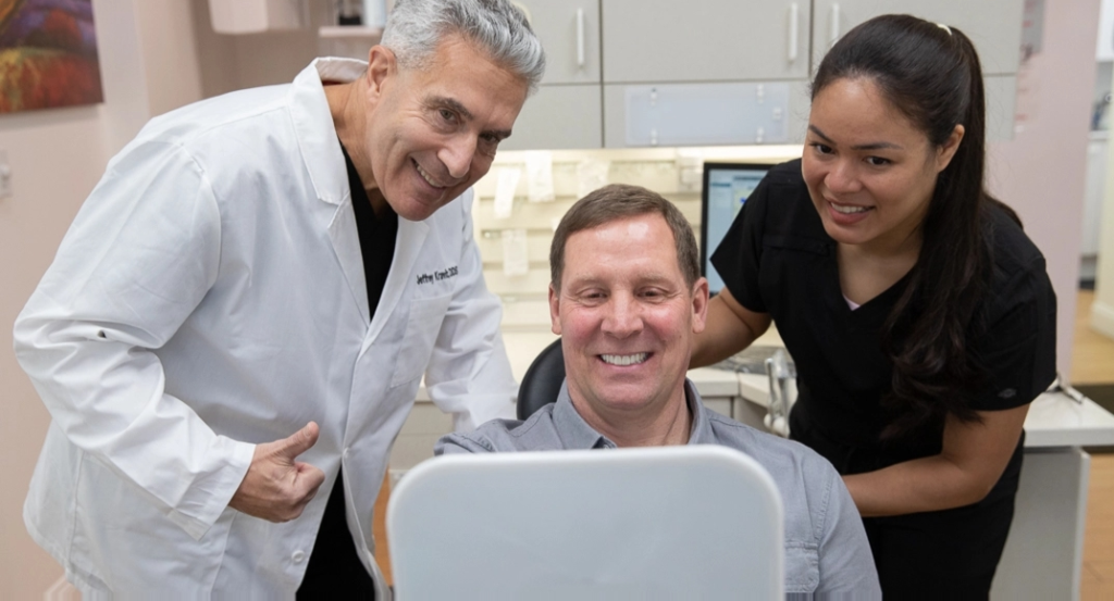 Dr. Jeffrey Kravitz with a patient and dental assistant, showcasing a positive dental experience in a modern office setting.